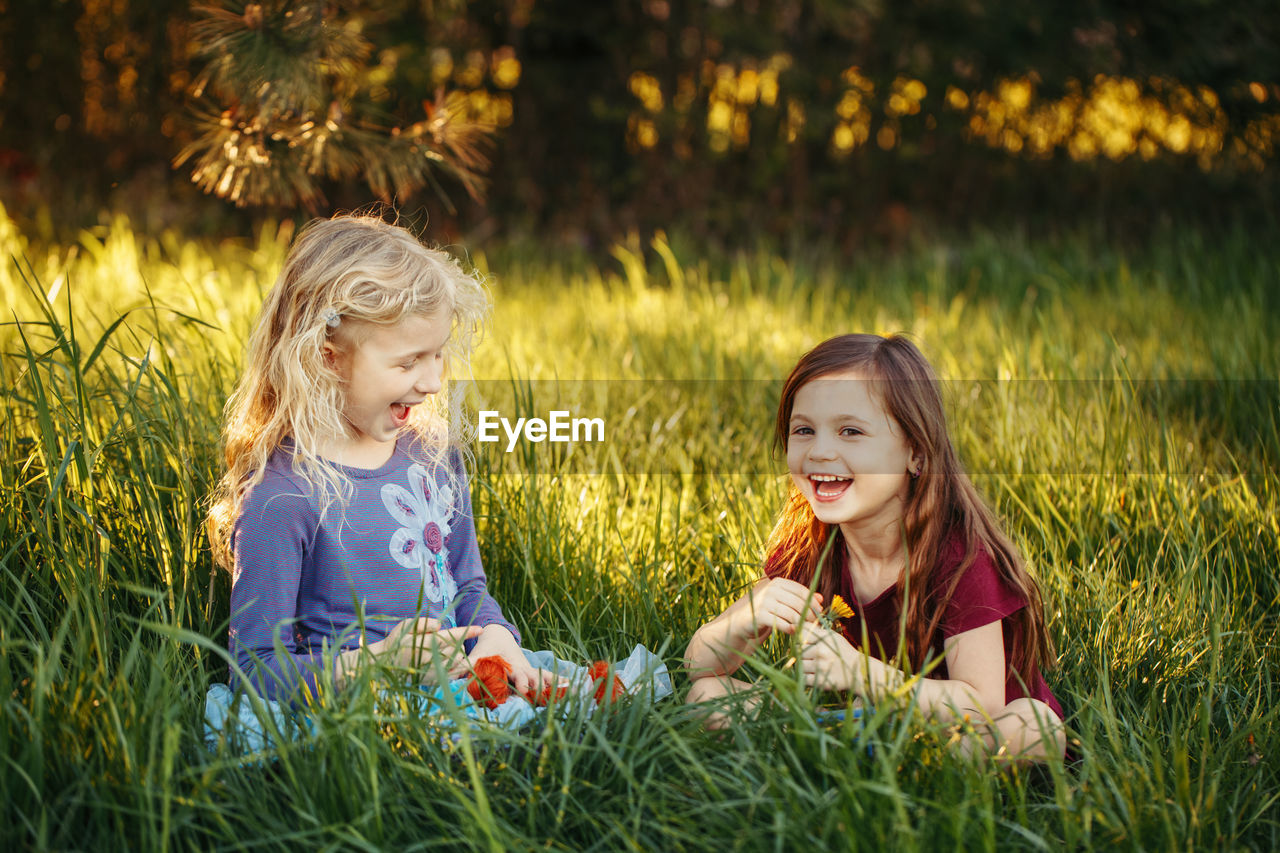 Happy children girls playing dolls in park. outdoor summer backyard activity for kids