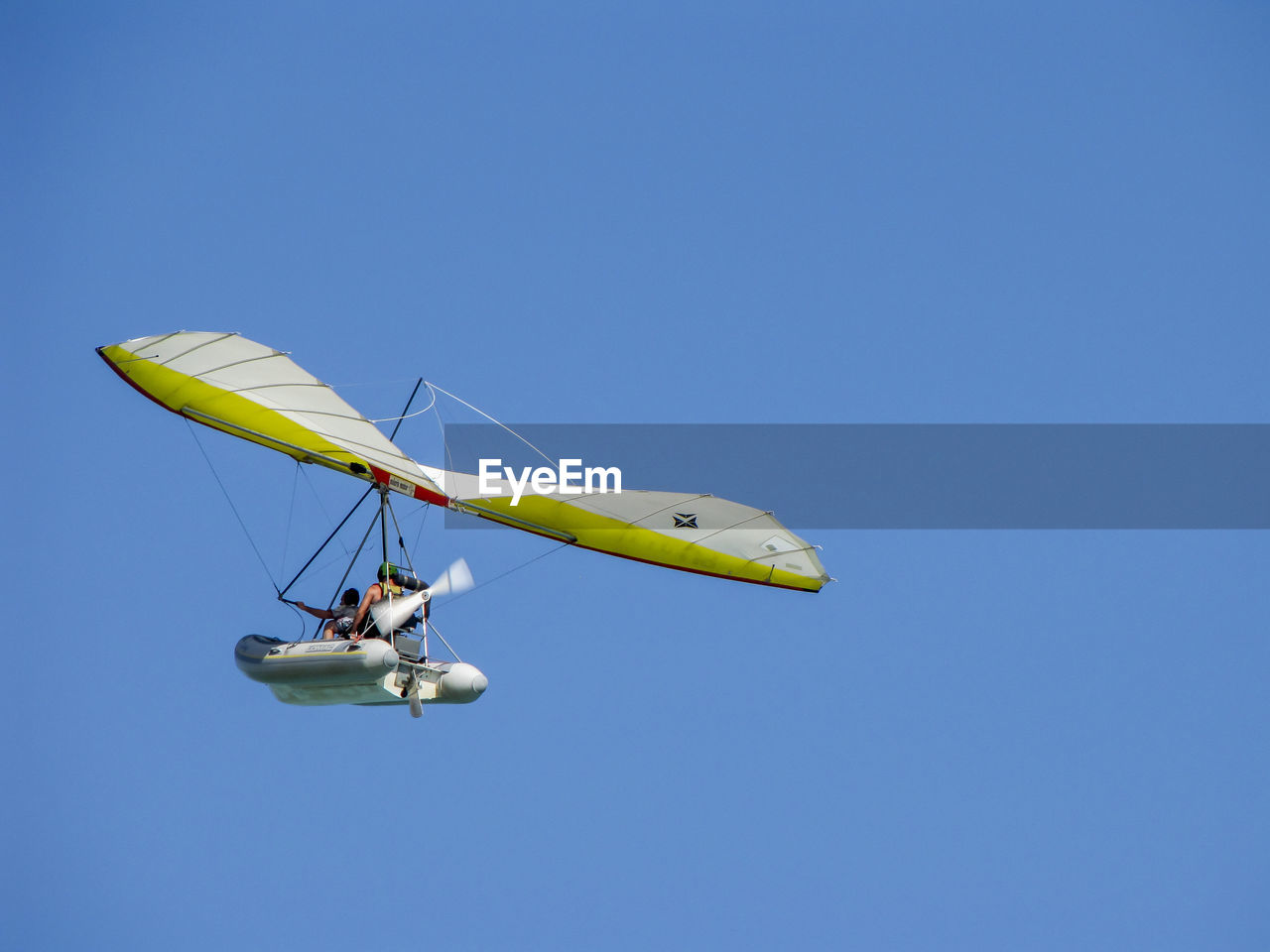 Low angle view of aircraft in flight against clear blue sky