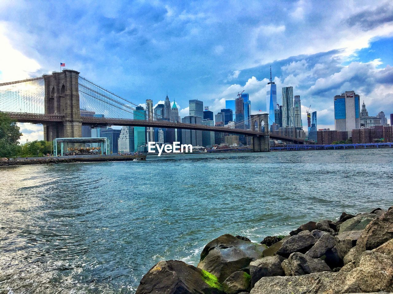 Bridge over river and buildings against sky