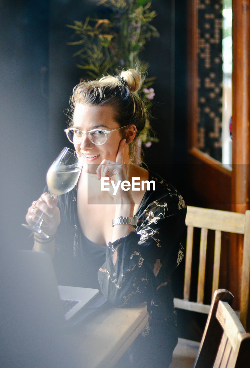 Portrait of woman drinking white wine after work