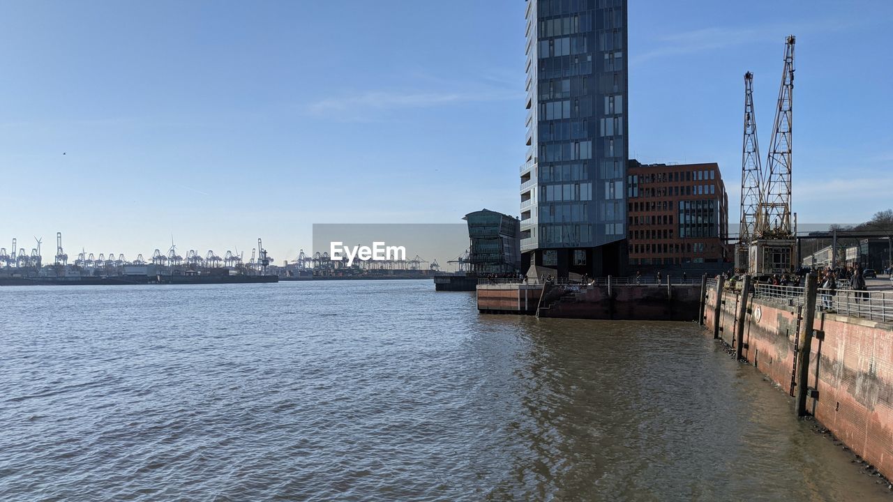 RIVER BY BUILDINGS AGAINST SKY