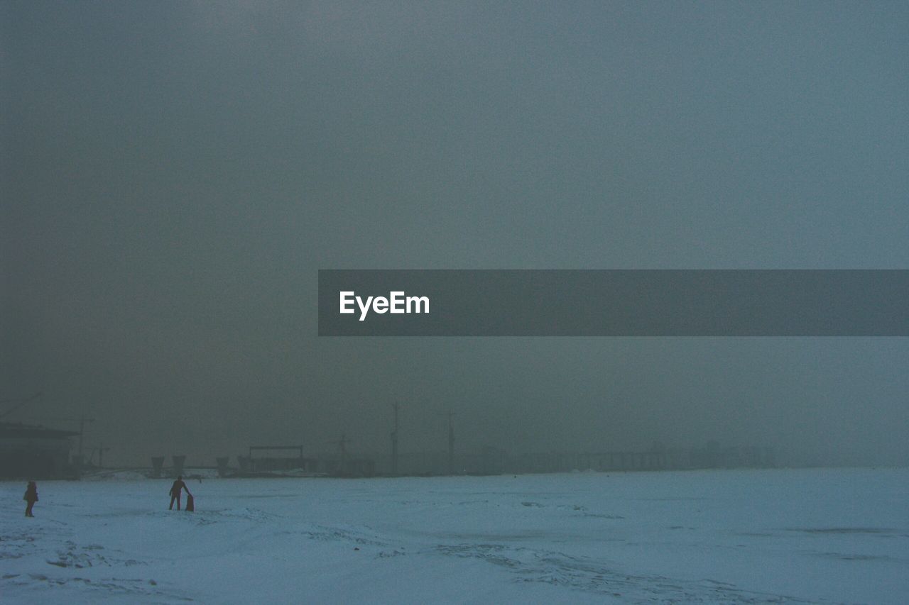 Distance shot of silhouette people on snowed landscape