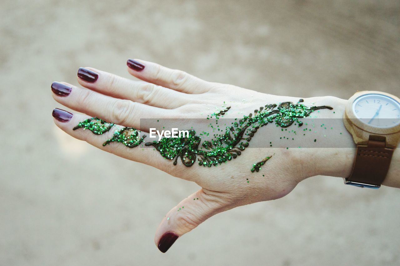 Cropped hand of woman with henna tattoo