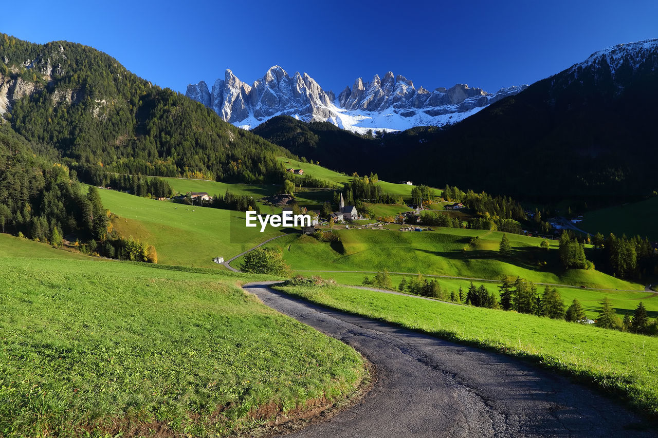 Scenic view of green landscape and mountains against sky