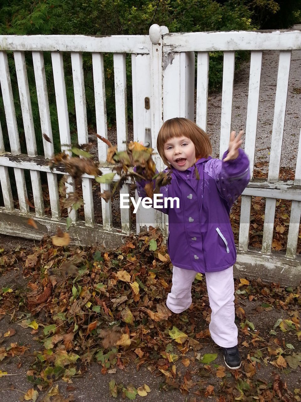 Full length of a girl standing against fence