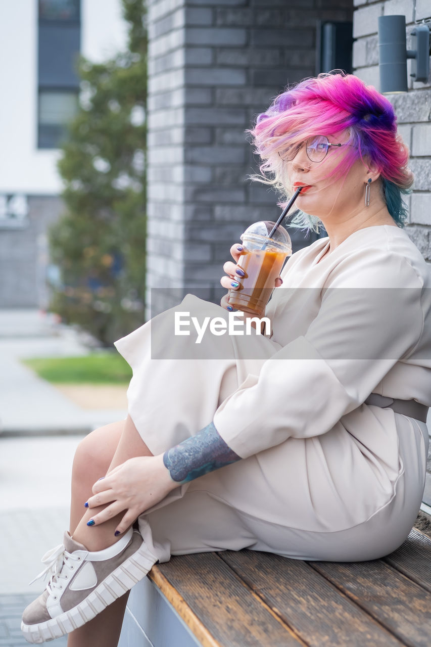 Woman drinking coffee while sitting outdoors