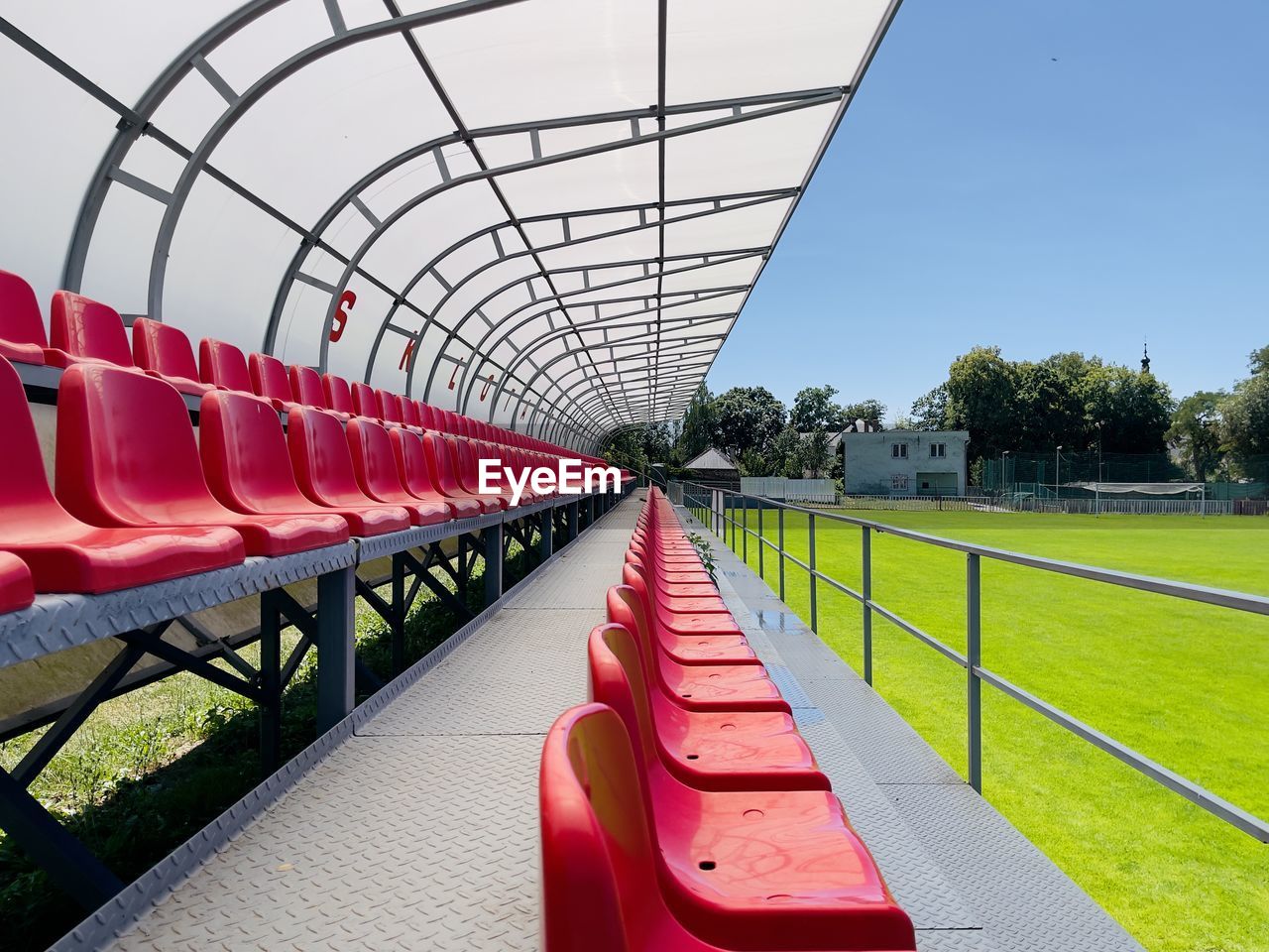 sports, seat, red, stadium, plant, architecture, grass, sky, empty, no people, nature, built structure, sport venue, day, race track, outdoors, absence