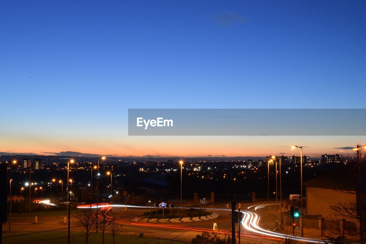 Illuminated cityscape against clear sky at night