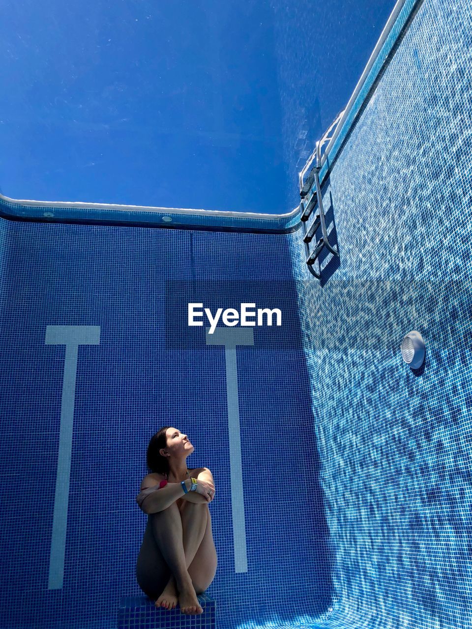 Woman sitting in swimming pool