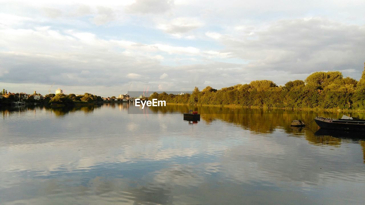 Scenic view of thames river against cloudy sky