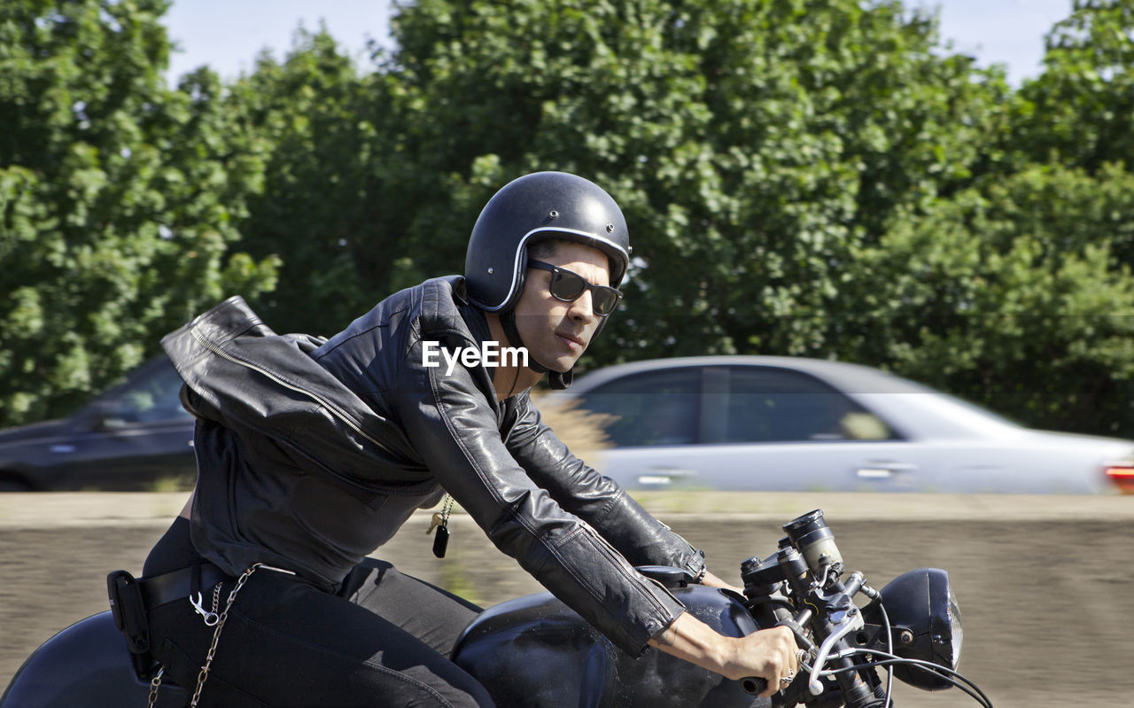 Confident man riding motorcycle on road