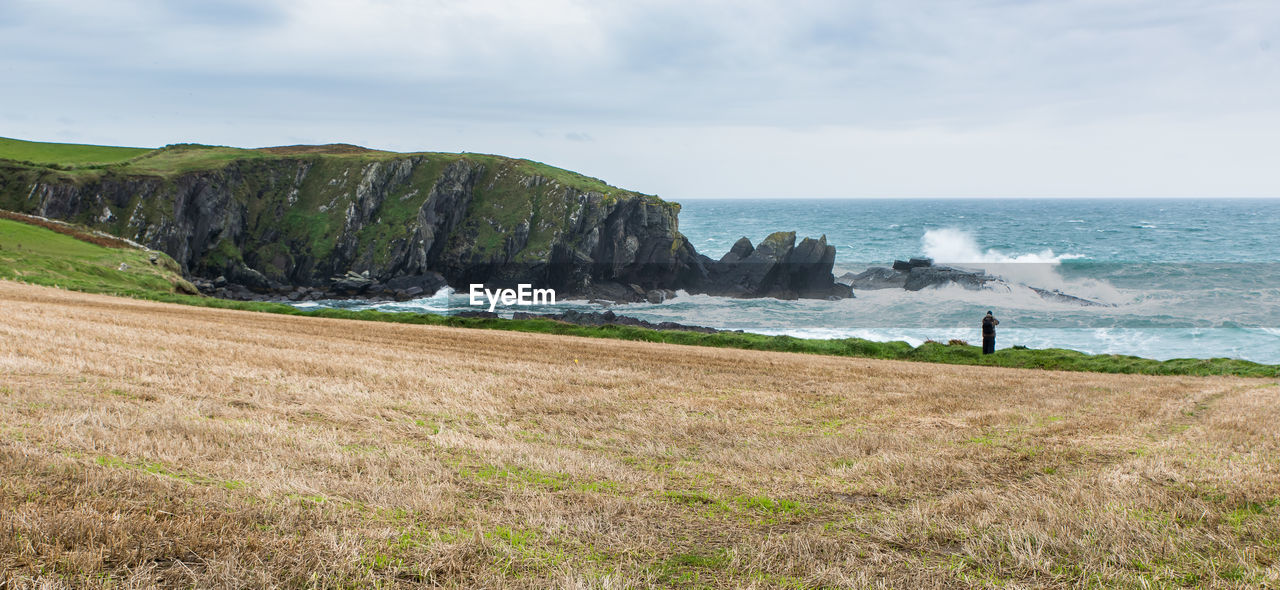 Scenic view of waves crashing on cliff