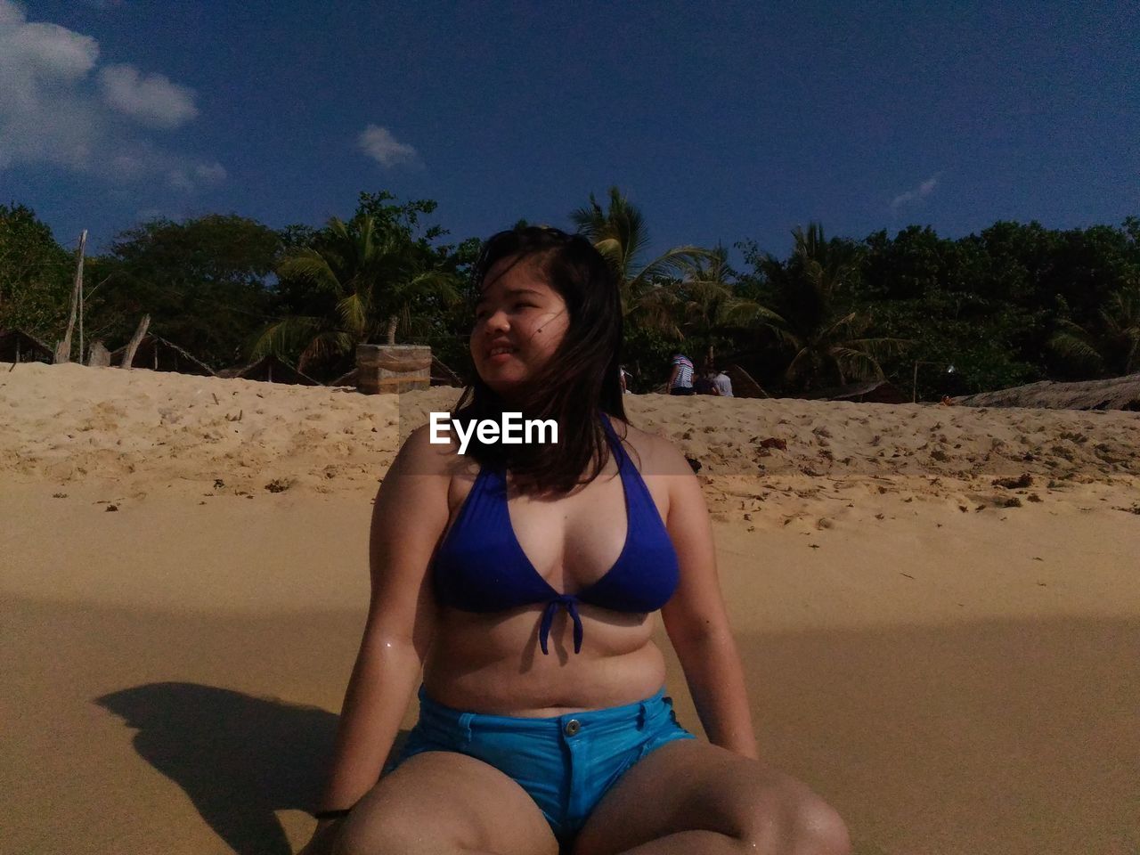 Young woman sitting on sand at beach