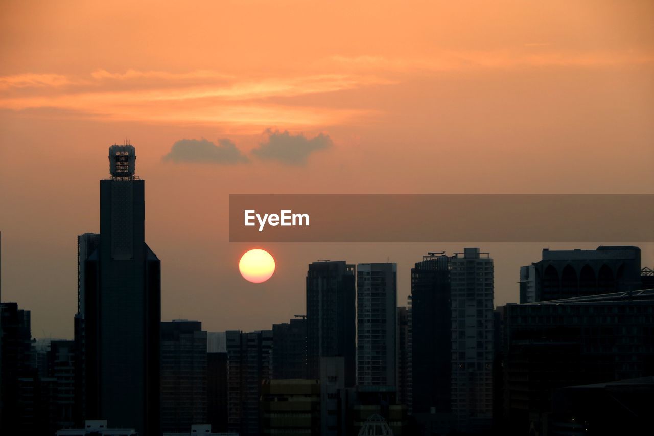 Modern buildings against sky during sunset