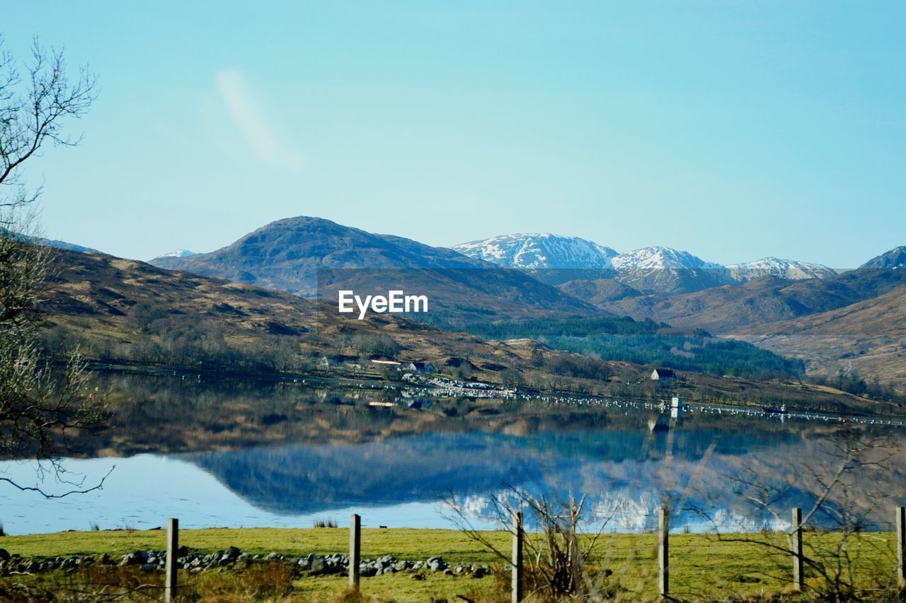 SCENIC VIEW OF TREES AND MOUNTAINS AGAINST CLEAR BLUE SKY