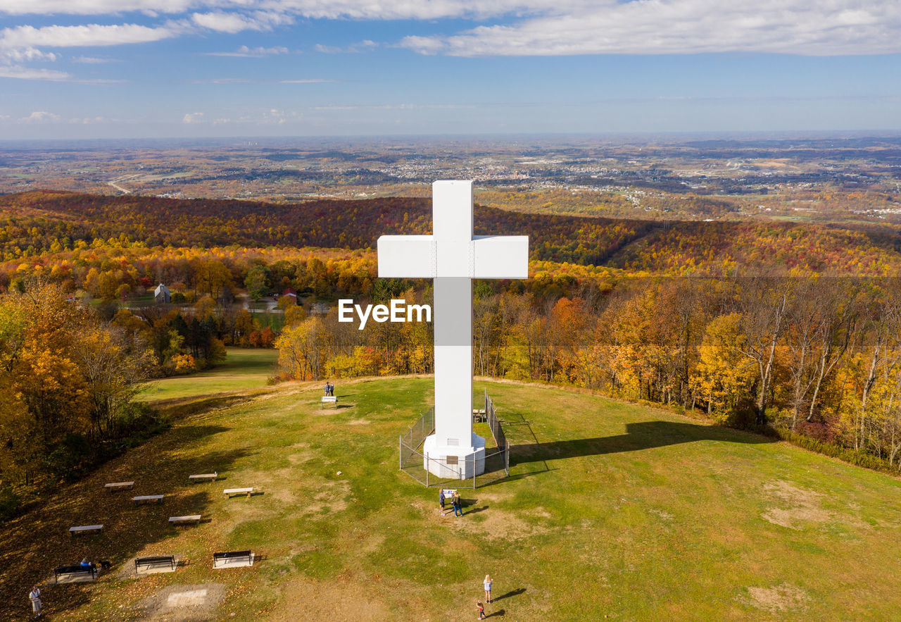 CROSS ON LANDSCAPE AGAINST SKY