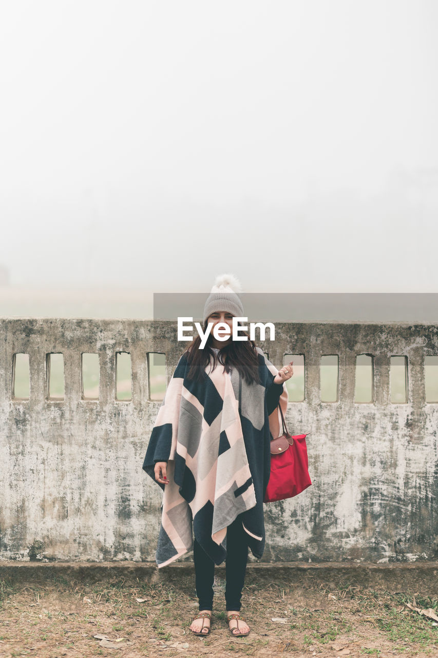 Portrait of woman standing against sky