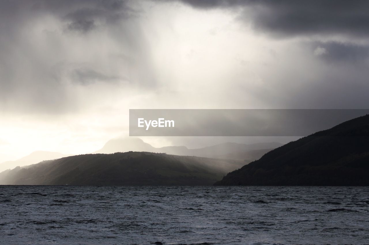 SCENIC VIEW OF MOUNTAINS AND SEA AGAINST SKY