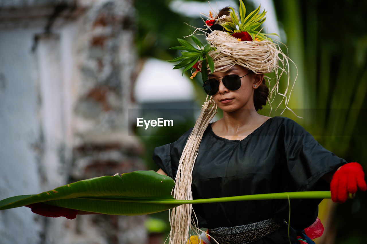 Woman with leaf standing outdoors