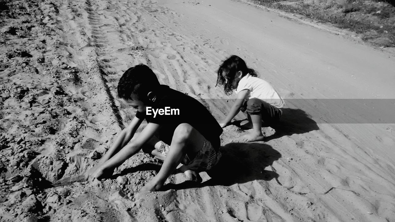 HIGH ANGLE VIEW OF WOMEN SITTING ON SAND