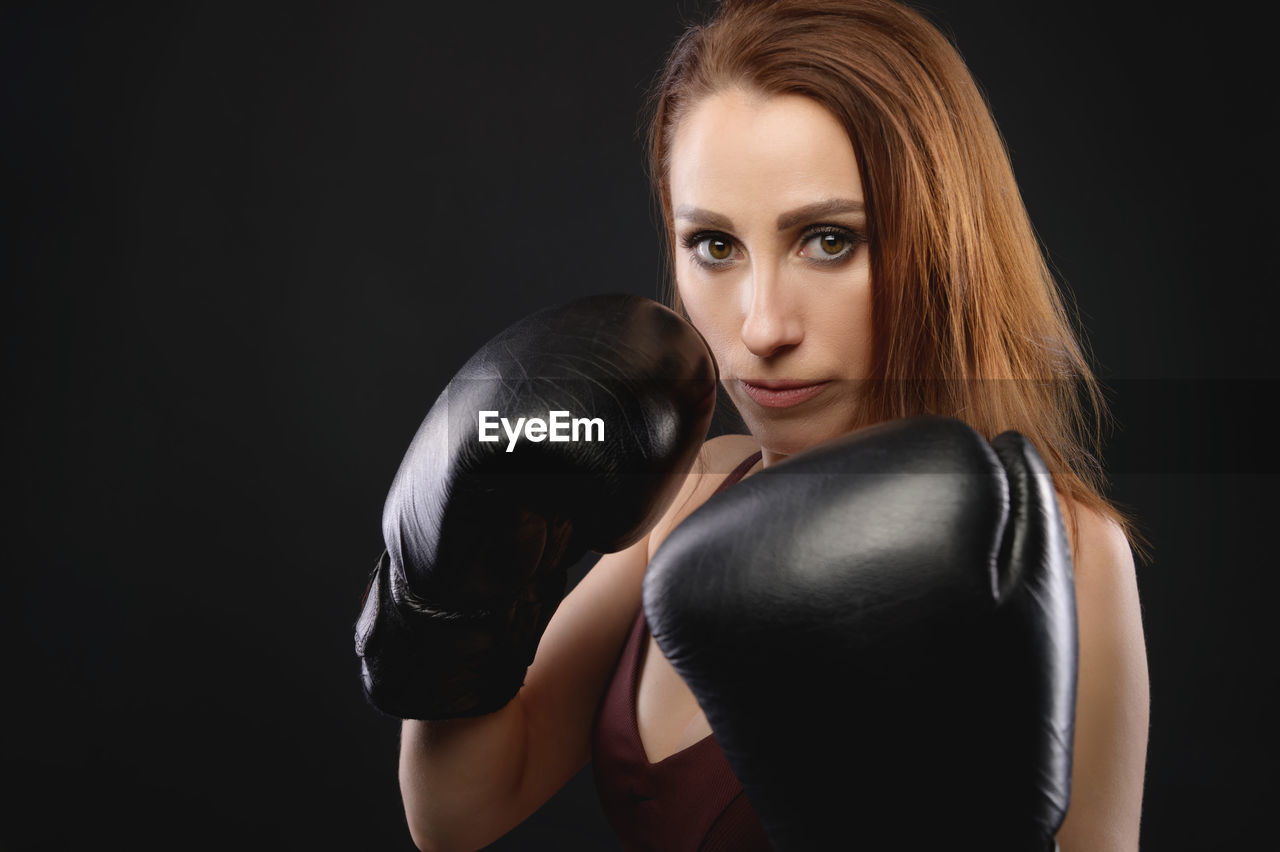 Portrait of woman against black background