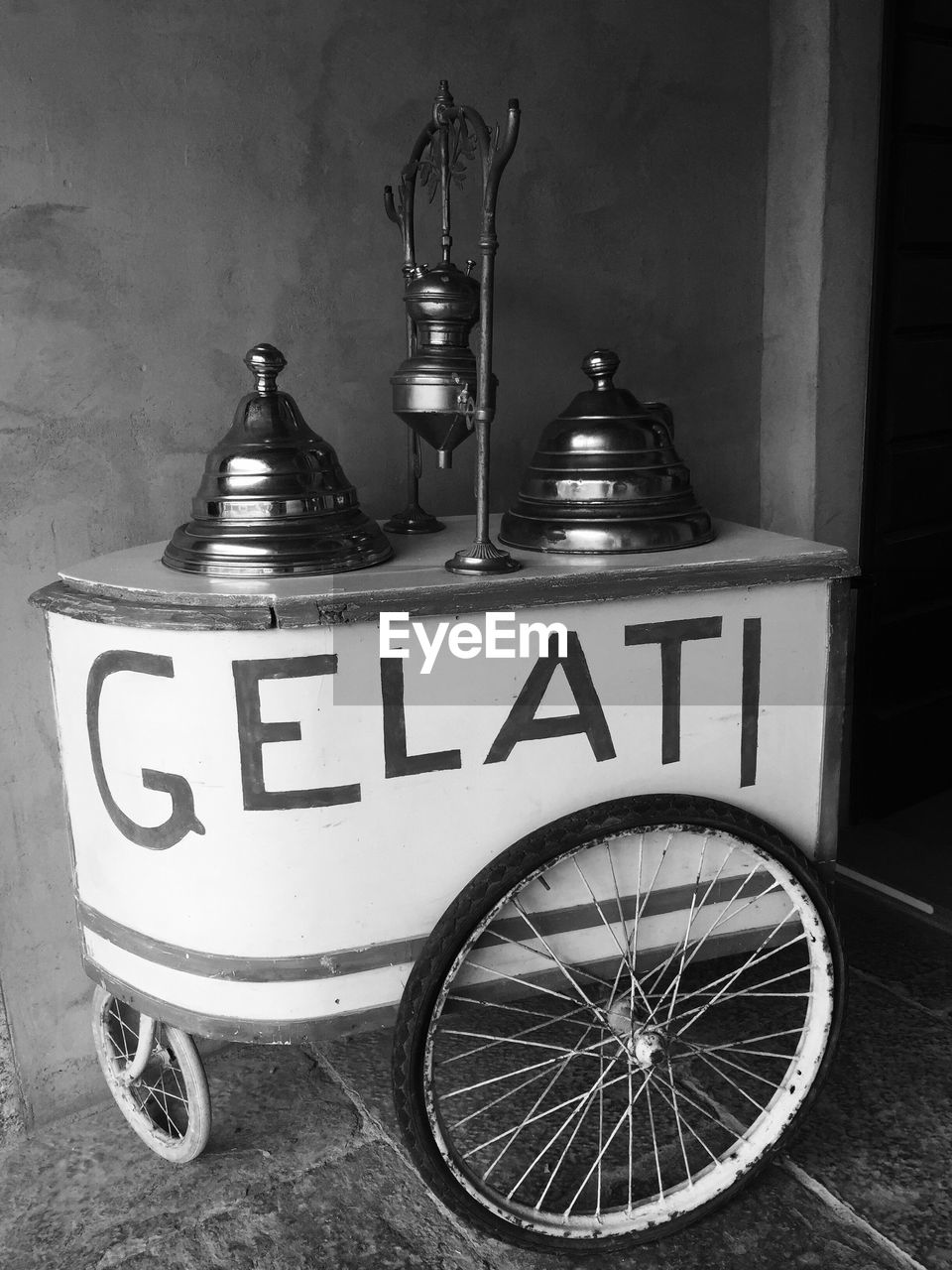 Text on ice cream cart against wall