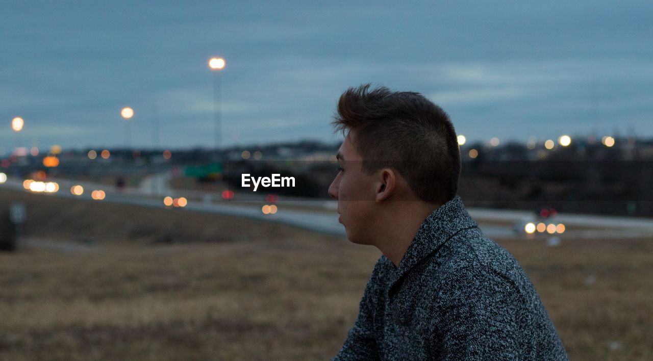 Side view of man on field at dusk