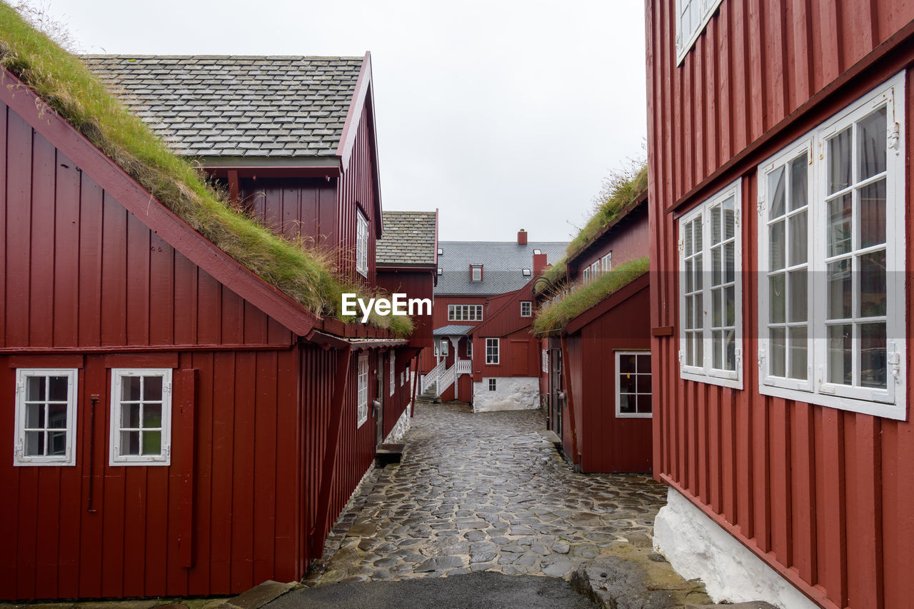 Empty alley amidst buildings against sky