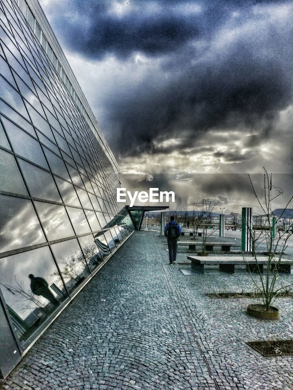 VIEW OF CITY STREET AGAINST CLOUDY SKY