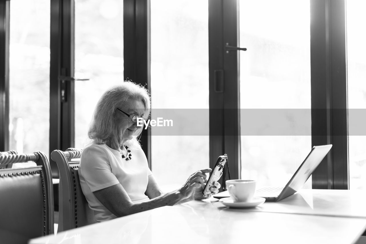 Woman using phone on table at home