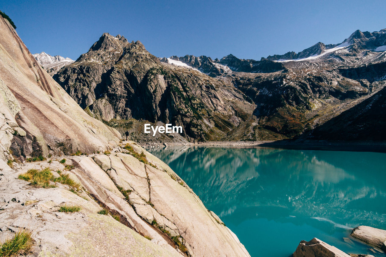 Scenic view of mountains against clear blue sky