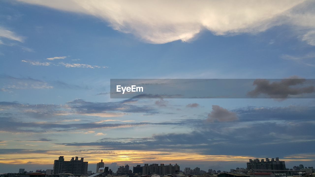 Buildings in city against sky during sunset