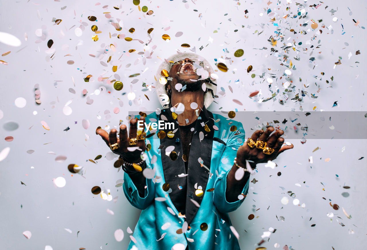 Portrait of happy man standing against multi colored background