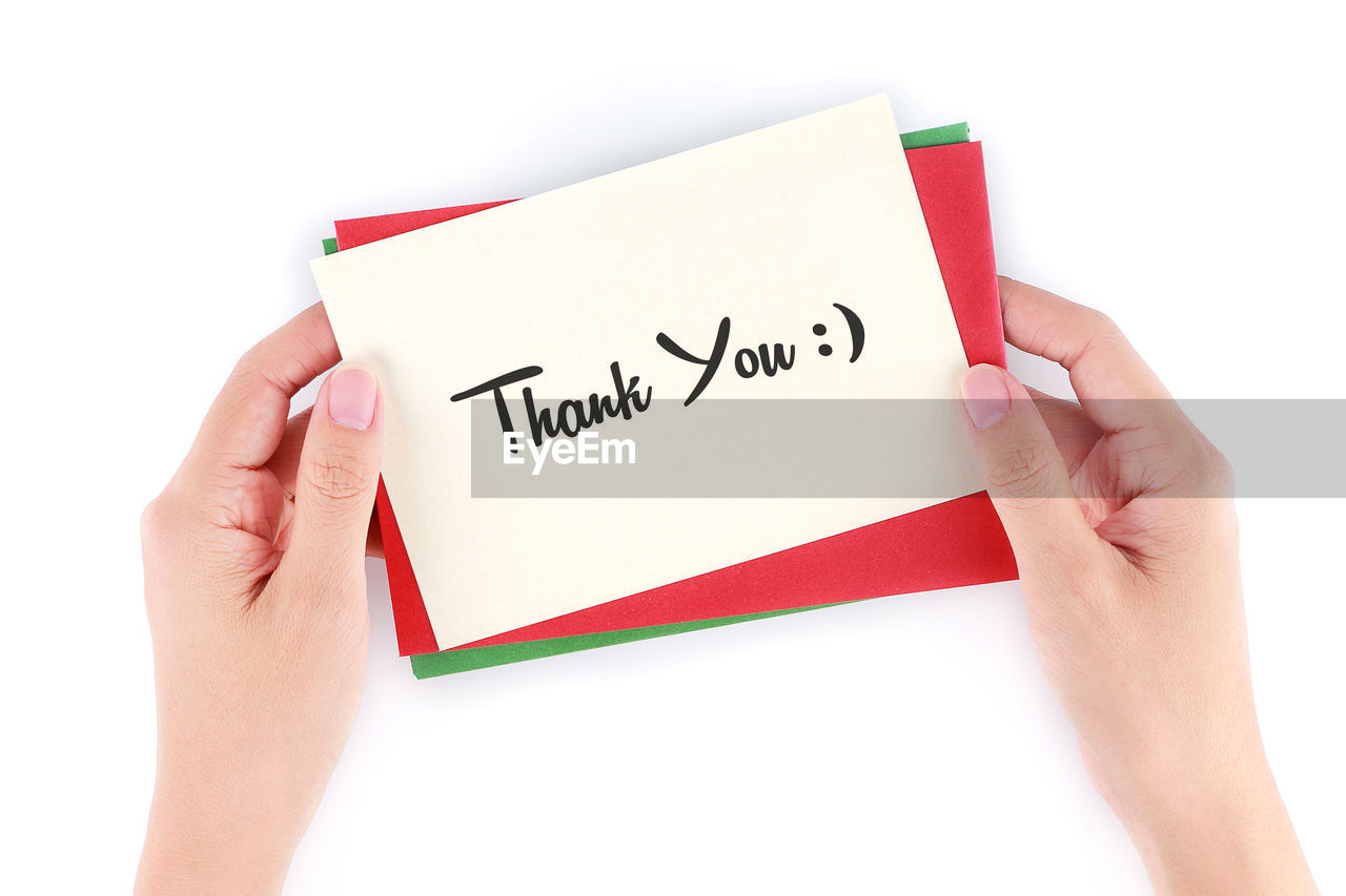 Cropped hands holding card with thank you text on white background