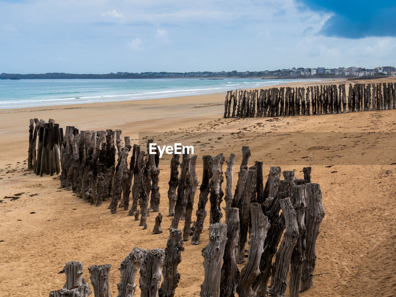 PANORAMIC VIEW OF WOODEN POSTS ON BEACH