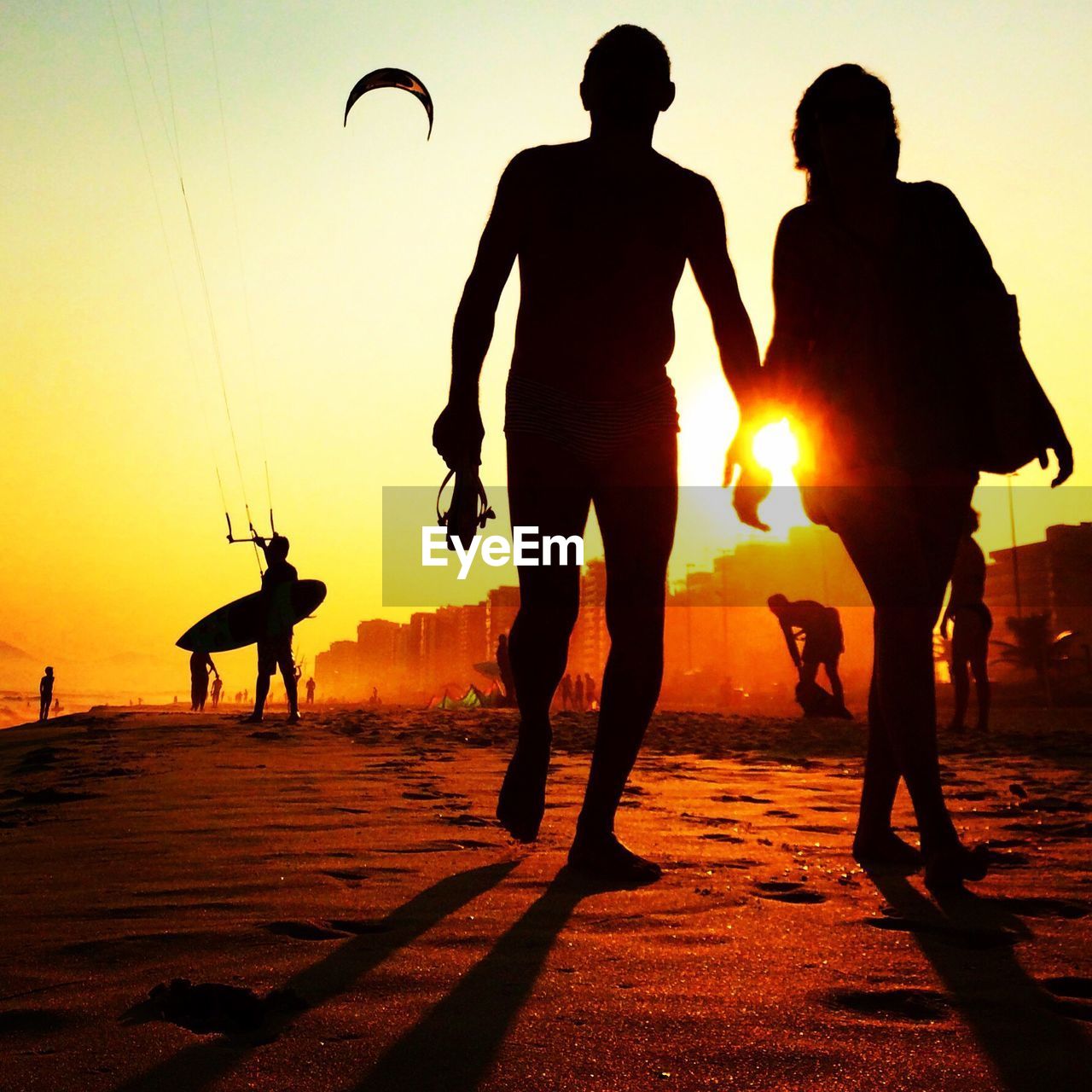 Low angle view of silhouette people on beach during sunset