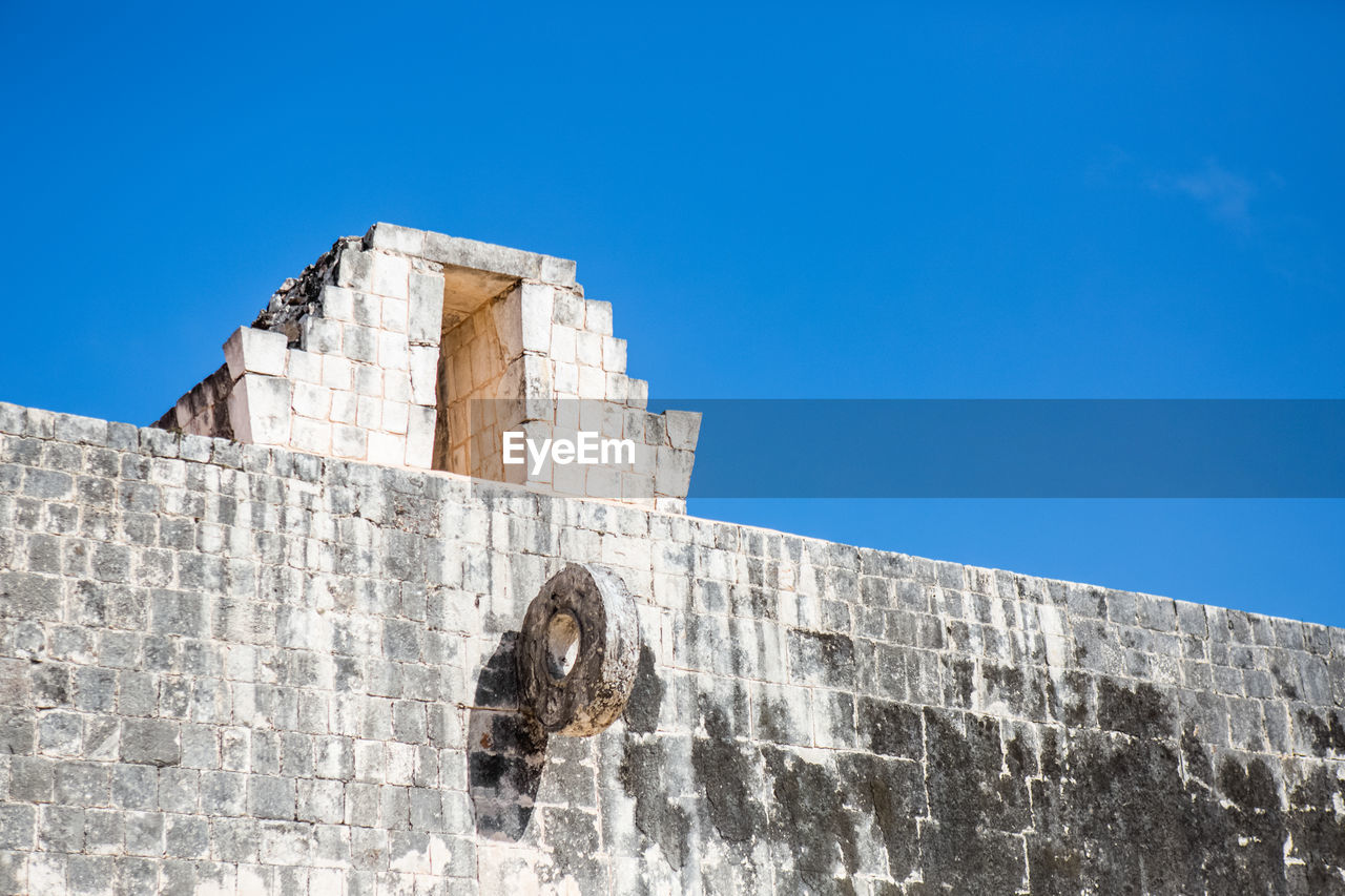 Low angle view of old ruin against clear blue sky