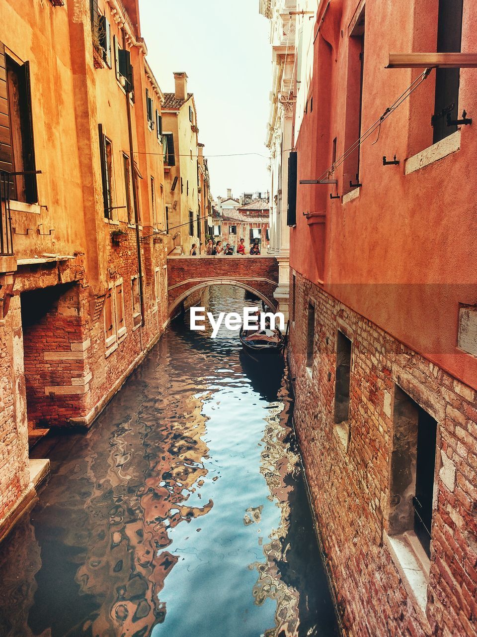 Canal amidst buildings against sky