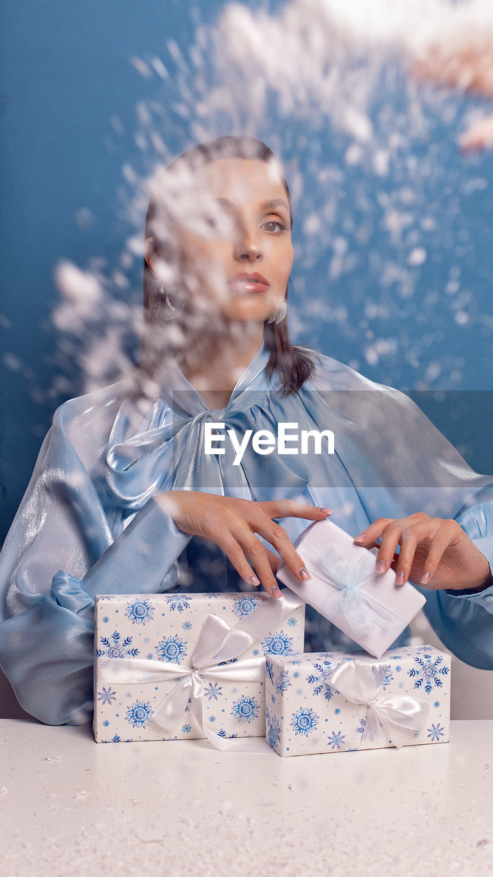 New year and women beauty concept. portrait of a beautiful woman sitting at a table at christmas