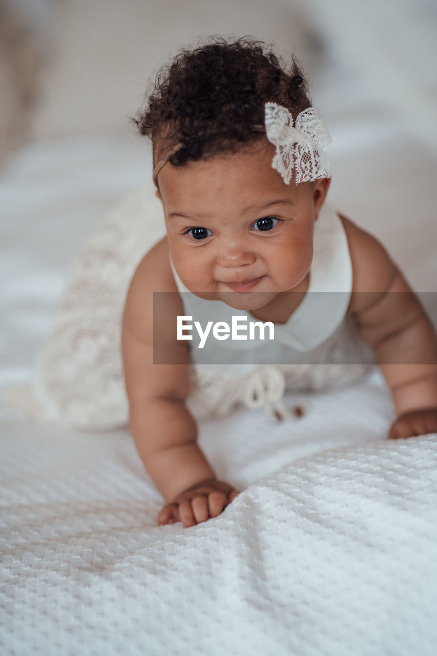 PORTRAIT OF CUTE BABY ON BED