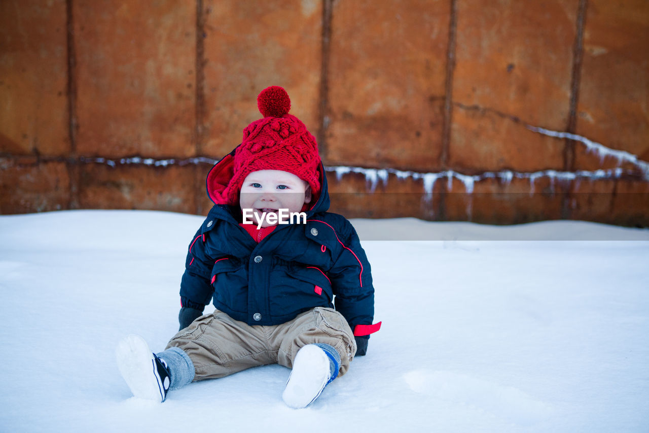 Cute boy in warm clothing on snow