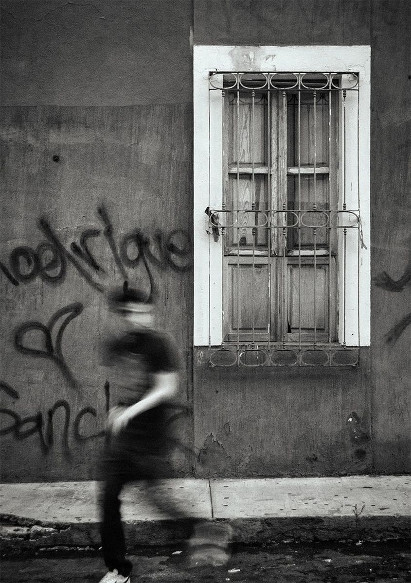 Side view of a blurred man walking against the road