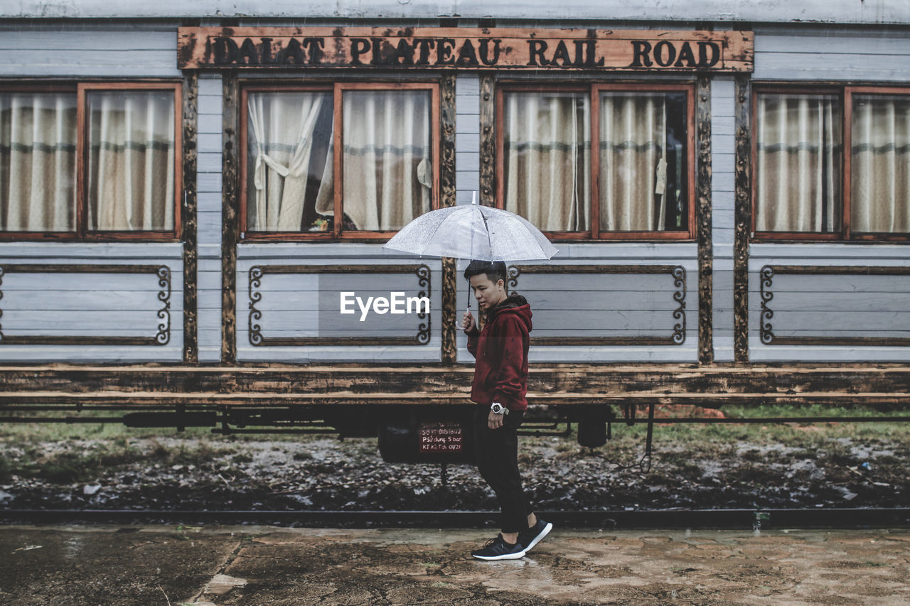 FULL LENGTH OF WOMAN WALKING IN RAIN