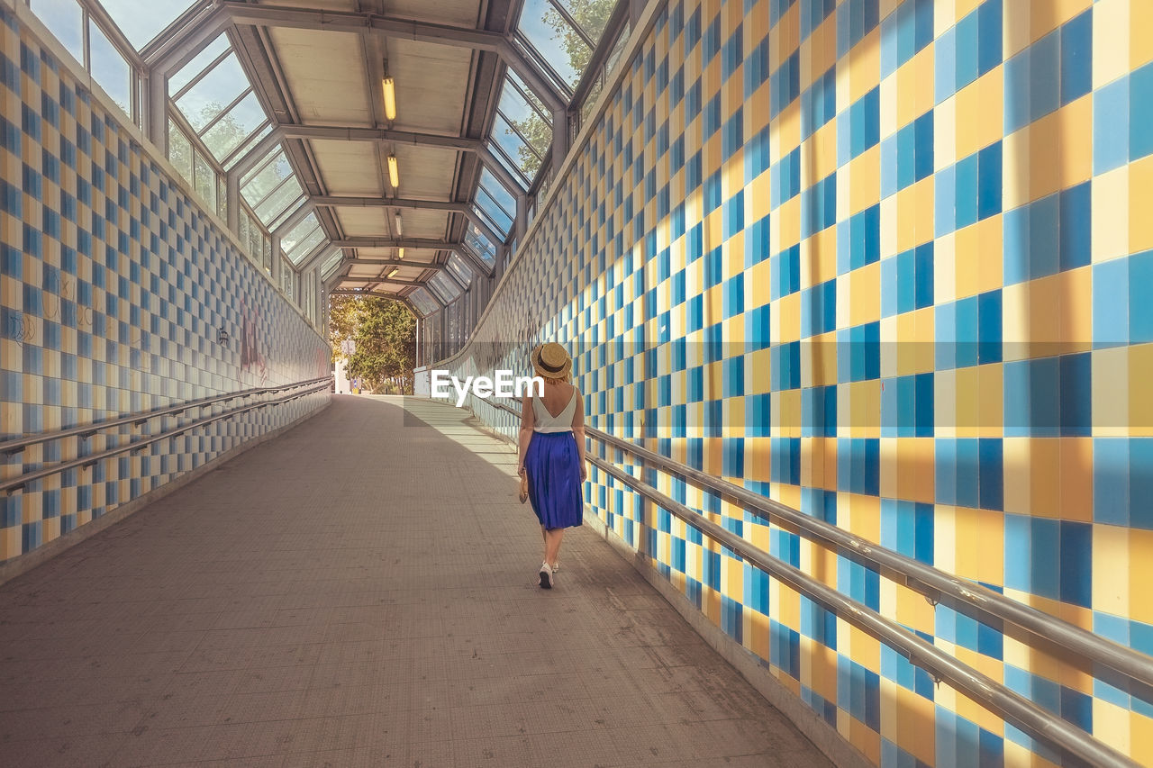 Rear view of woman walking on footpath