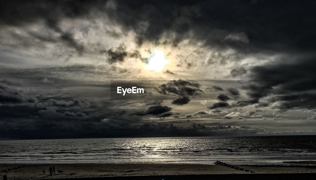 SCENIC VIEW OF SEA AGAINST CLOUDY SKY DURING SUNSET