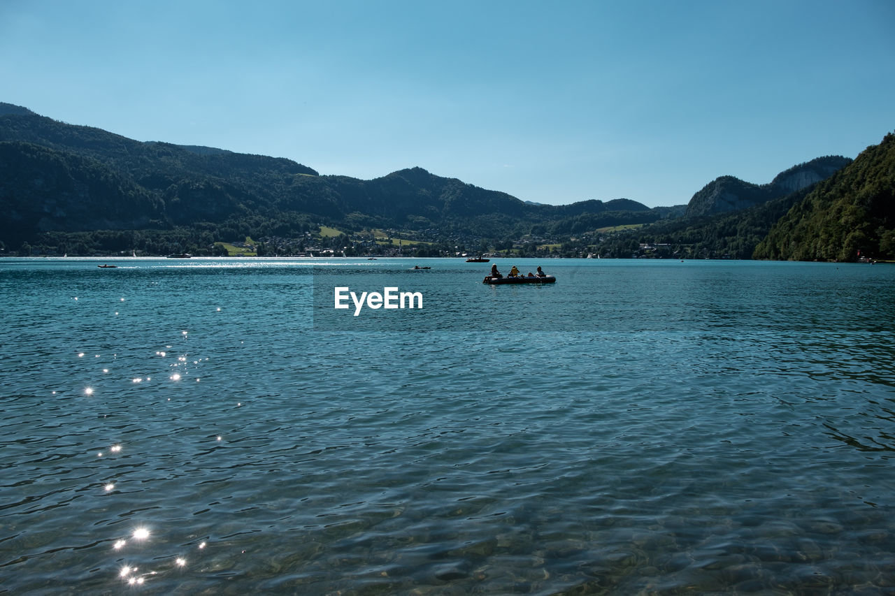SCENIC VIEW OF SEA AND MOUNTAINS AGAINST CLEAR SKY