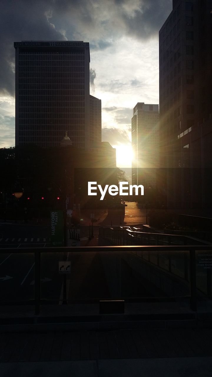 SUN SHINING THROUGH CLOUDS OVER CITY