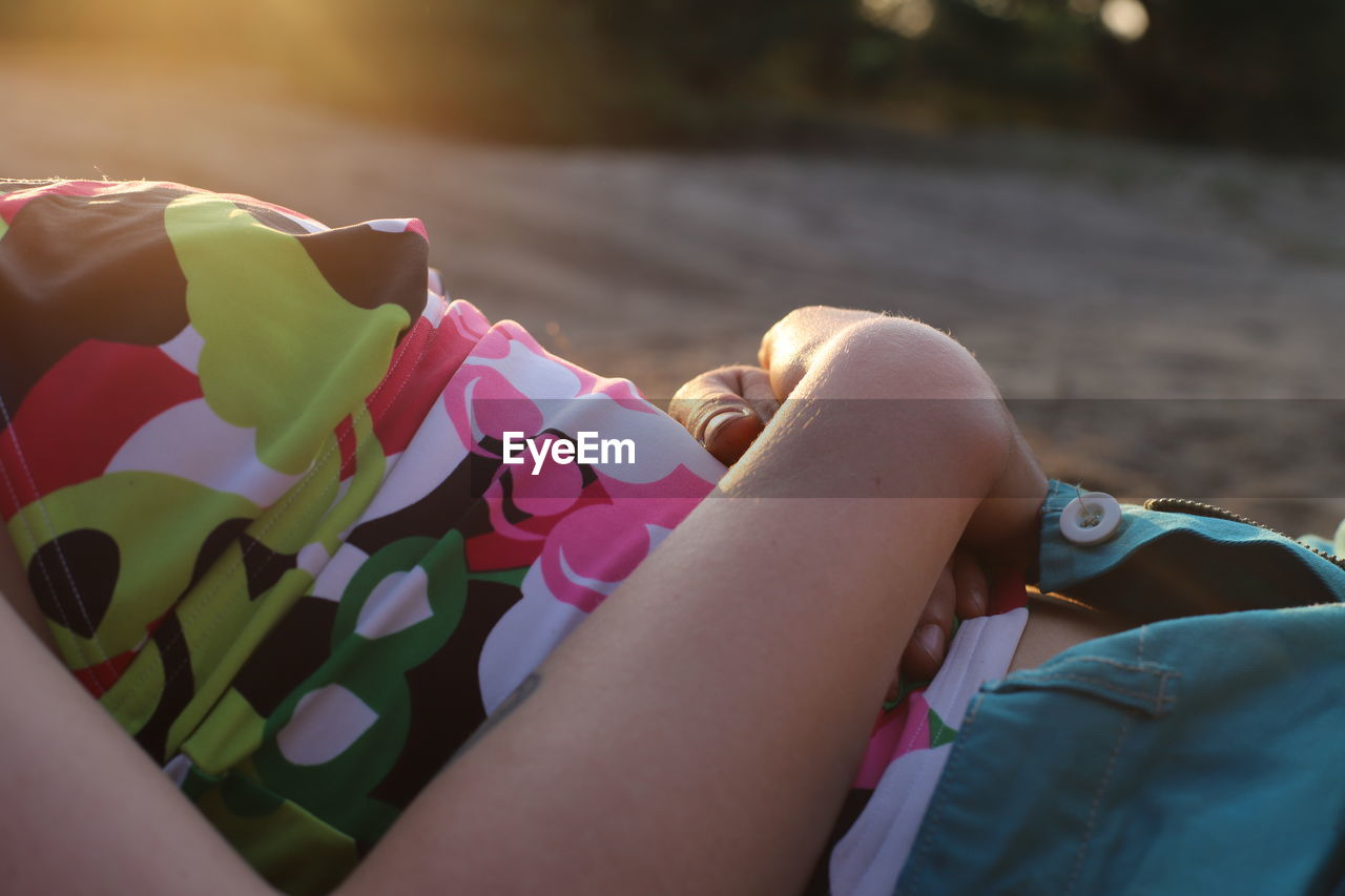 Midsection of woman lying at beach