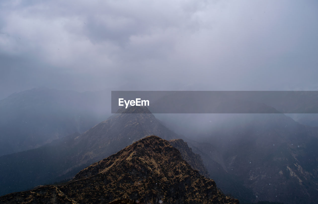 Scenic view of mountains against sky during foggy weather