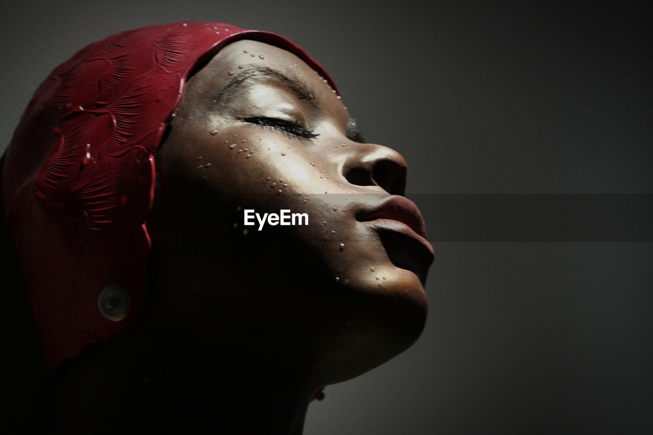 Close-up of wet woman against gray background